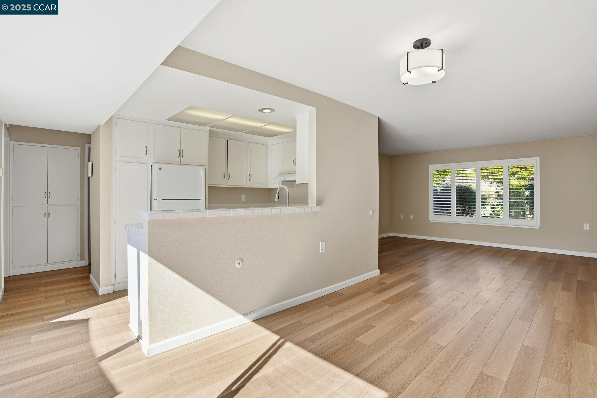 2425 Pine Knoll Drive, Unit 1 Walnut Creek, CA 94595 - Photo 8 of 43 an empty room with wooden floor and windows