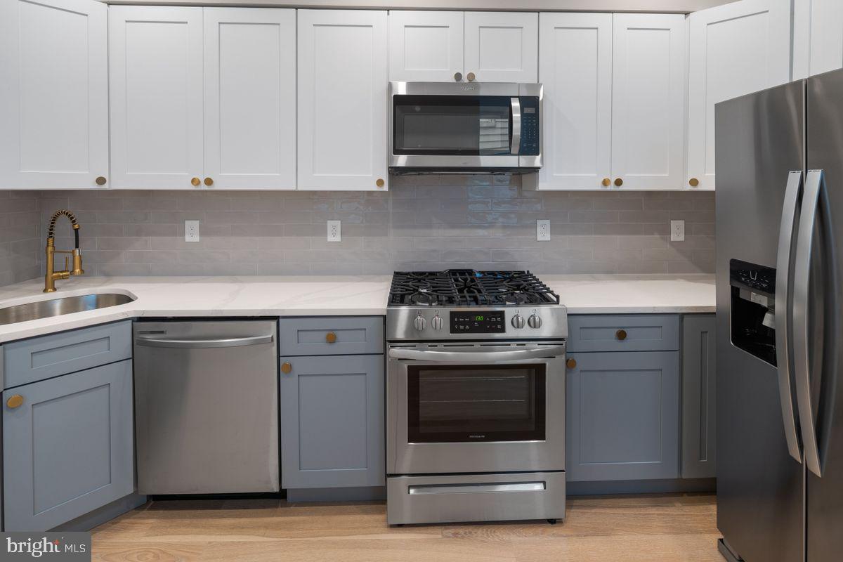 4129 Terrace Street Philadelphia, PA 19128 - Photo 7 of 27 a kitchen with stainless steel appliances granite countertop a stove a refrigerator and a white cabinets