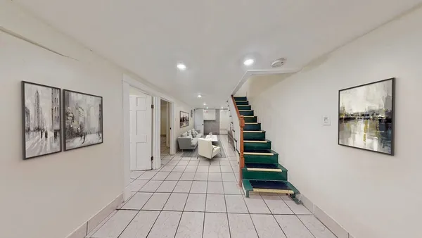 a view of a hallway with stairs and wooden floor