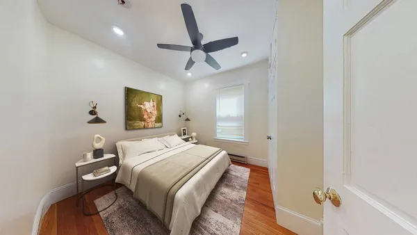 a bedroom with a bed and wooden floor