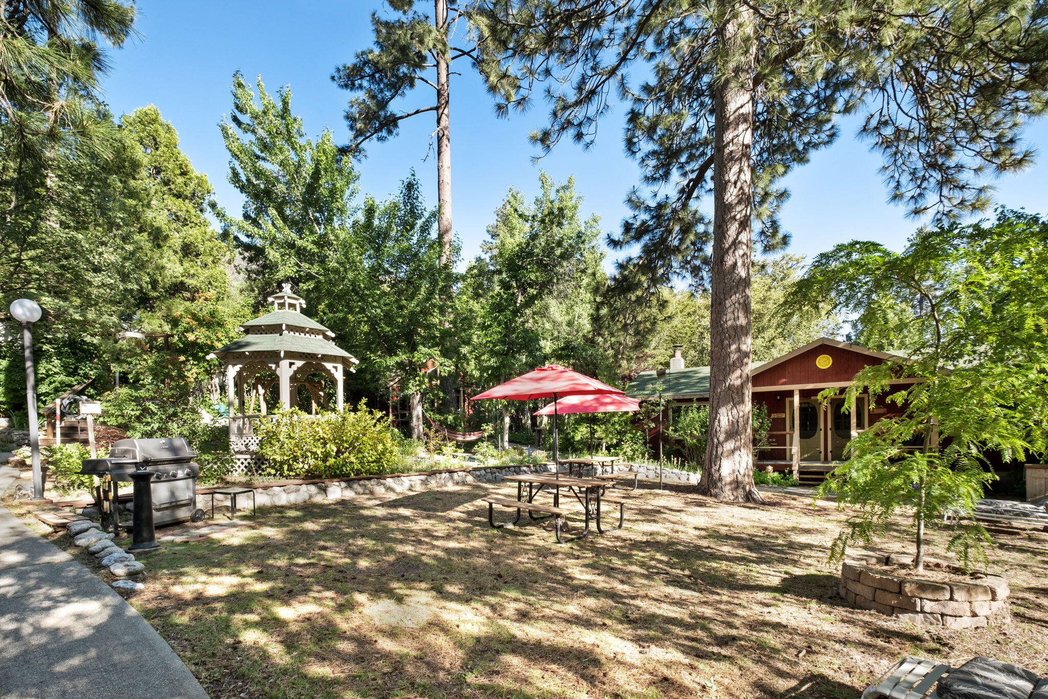 25210 Fern Valley Road Idyllwild, CA 92549 - Photo 109 of 127 a front view of a house with a yard and table and chairs under an umbrella