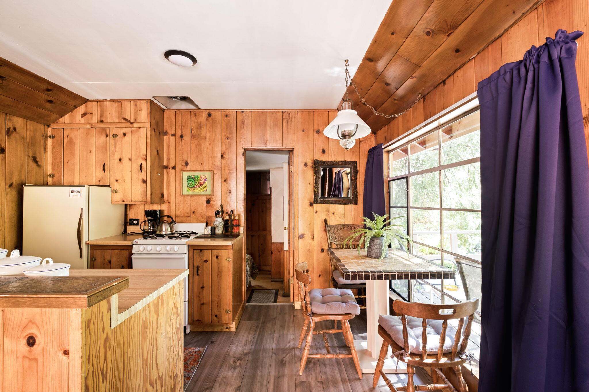 25210 Fern Valley Road Idyllwild, CA 92549 - Photo 34 of 127 a kitchen with stainless steel appliances kitchen island granite countertop a refrigerator a stove a sink dishwasher and a dining table with wooden floor