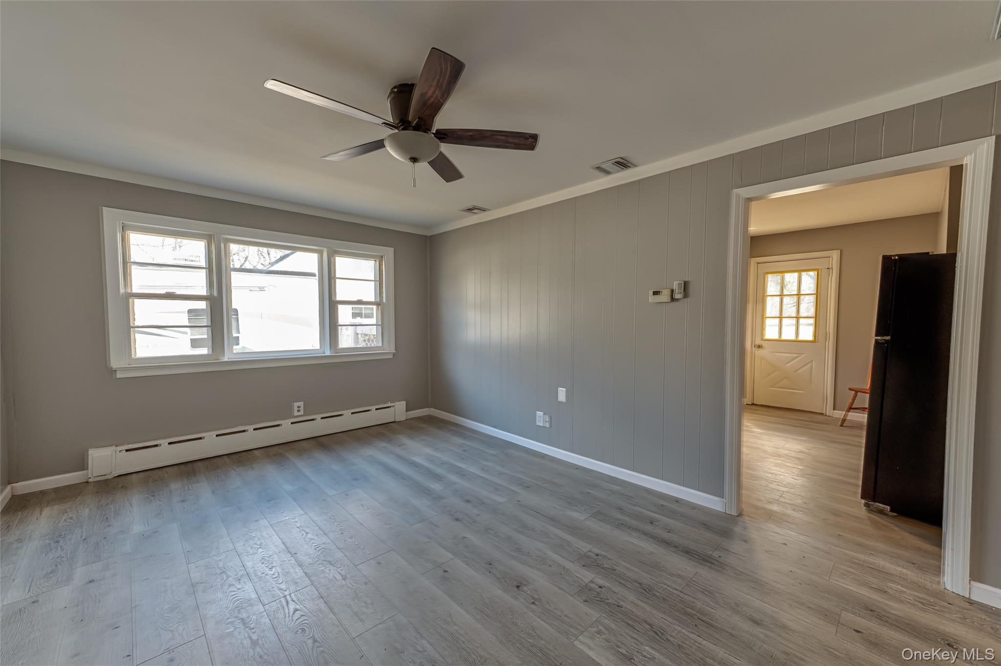 157 Hawthorne Street Mastic, NY 11950 - Photo 8 of 12 a view of an empty room with wooden floor and a window