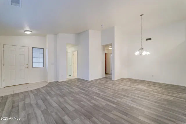 a view of a room with wooden floor and ceiling fan
