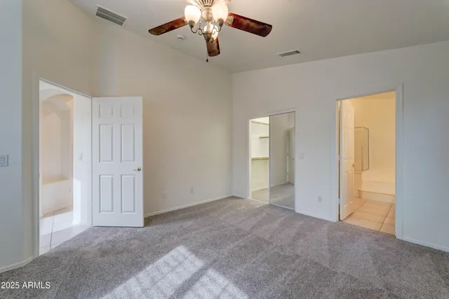 a view of an empty room with a chandelier fan