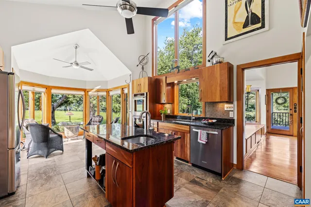 a kitchen with stainless steel appliances granite countertop a sink a stove and a refrigerator