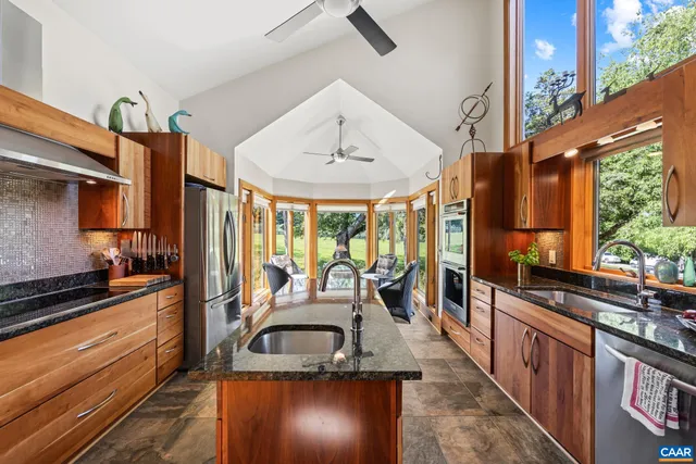a living room with furniture and floor to ceiling windows