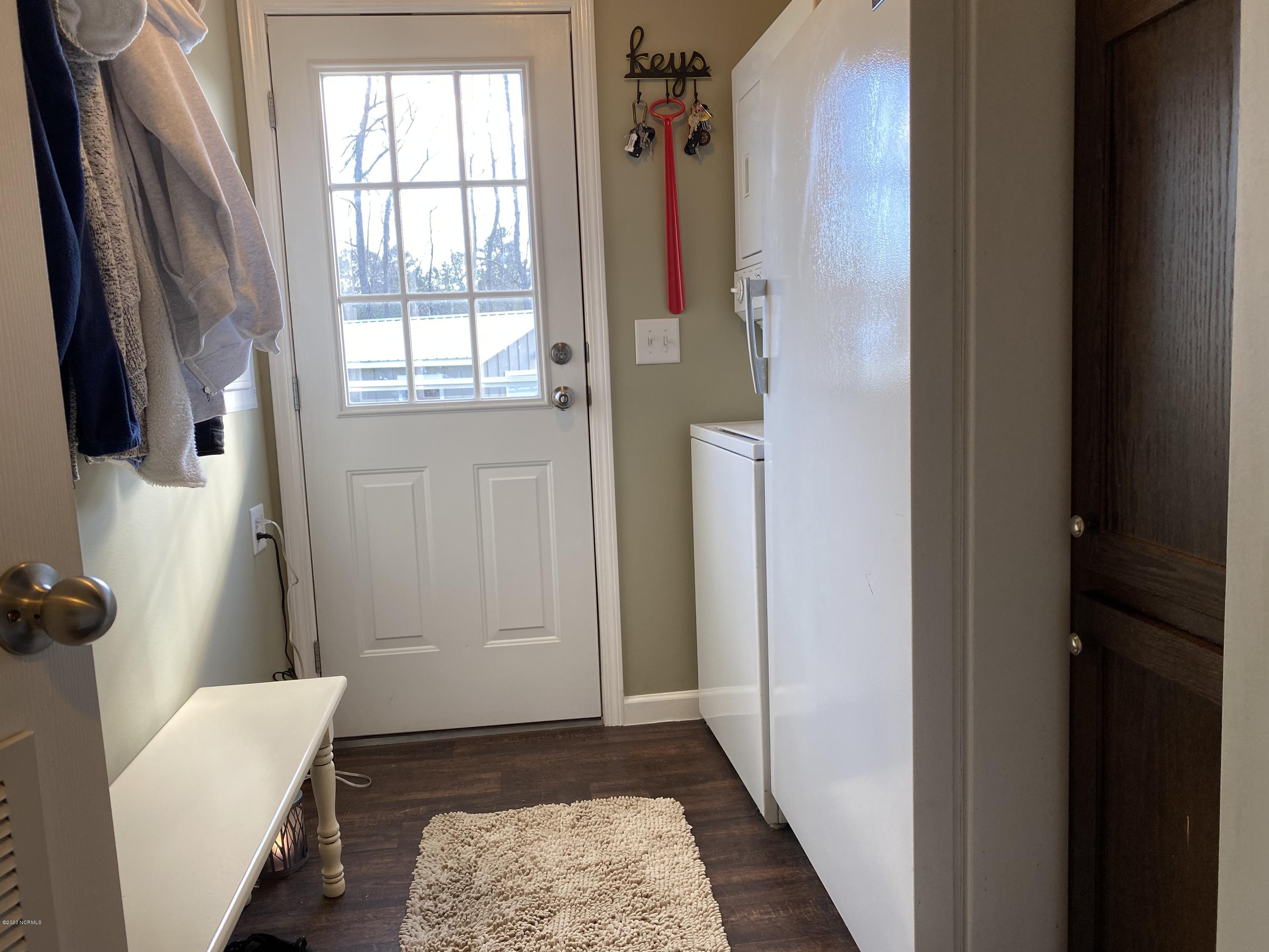 7022 Kingtown Road Northwest Ash, NC 28420 - Photo 28 of 34 Easy access to the detached garage form the Utility Room. Side entrance has a small deck with seating. The stackable washer and dryer will convey.