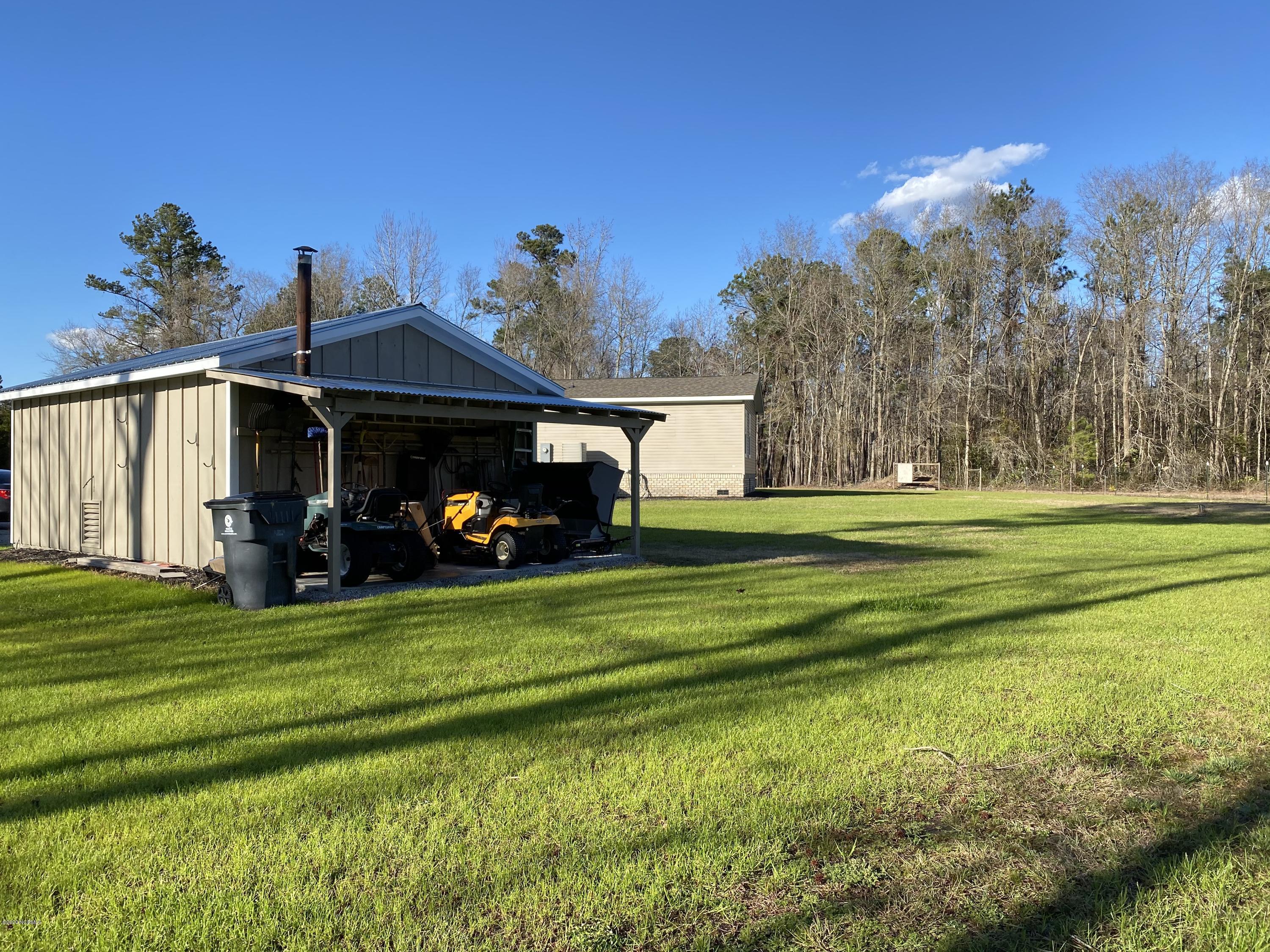 7022 Kingtown Road Northwest Ash, NC 28420 - Photo 32 of 34 One car detached garage has a wood stove and an attached lean-to