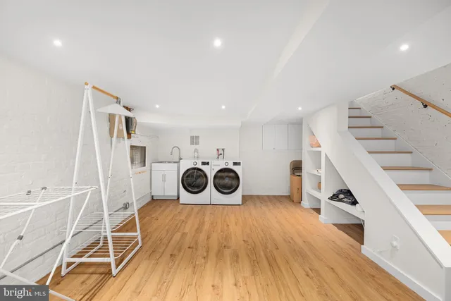 a utility room with wooden floor and cabinets