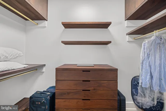 a view of walk in closet with clothes