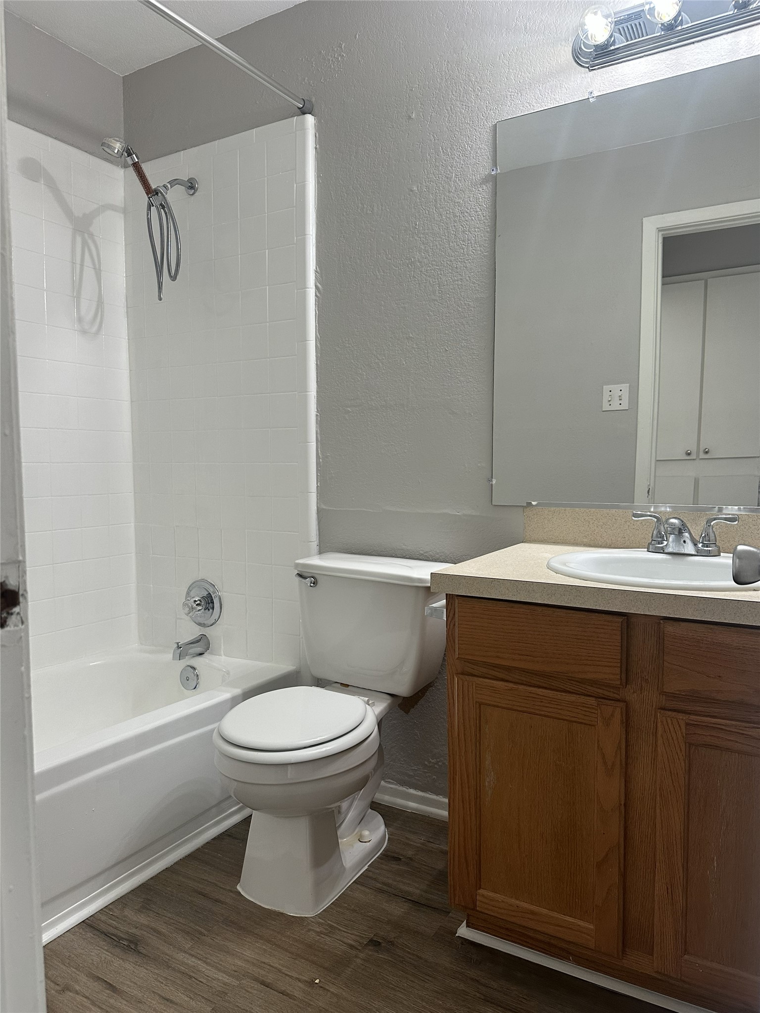 5724 Signal Point Austin, TX 78724 - Photo 12 of 17 Bathroom featuring a textured wall, vanity, dark wood-style flooring, and tub / shower combination