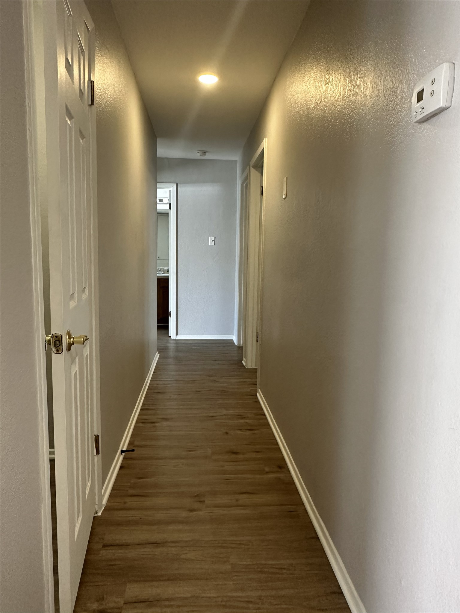 5724 Signal Point Austin, TX 78724 - Photo 9 of 17 Corridor with a textured wall and dark wood finished floors