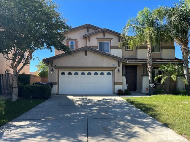 a view of a house with a yard and a garage