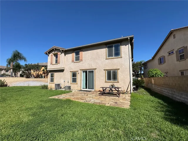 a view of a house with backyard and sitting area