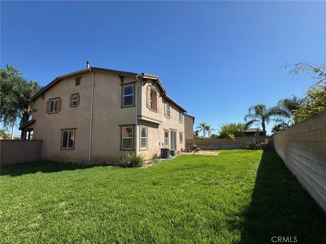 a large house with a big yard and large trees