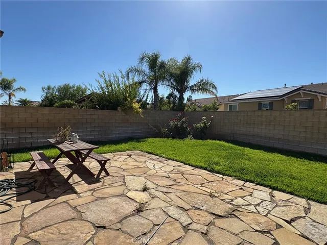 a view of a backyard with plants and a patio