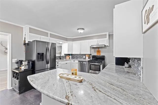 a kitchen with a refrigerator a stove and a sink