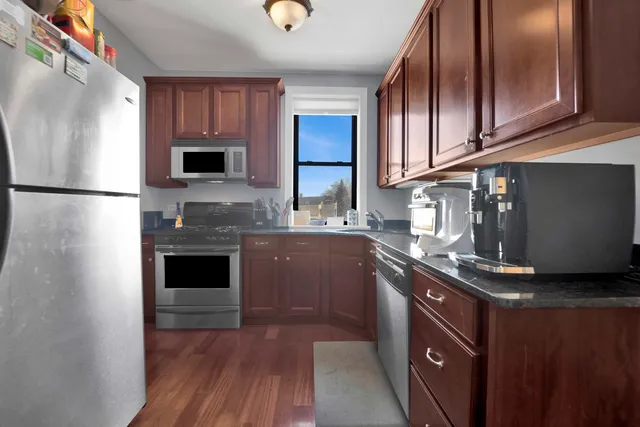 a kitchen with stainless steel appliances granite countertop a refrigerator a stove a sink and a microwave