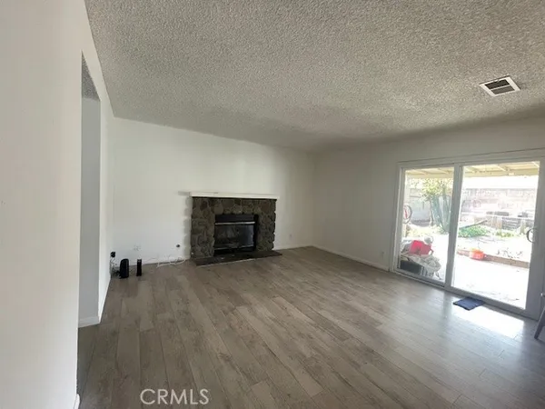 a view of empty room with wooden floor and fireplace