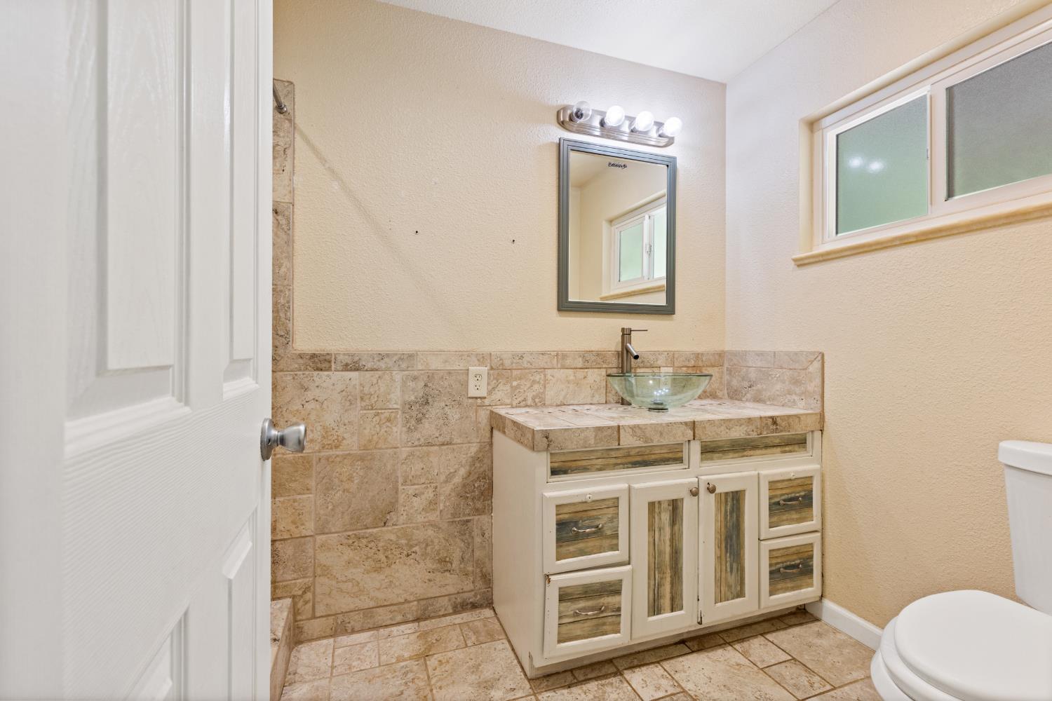 2971 Letitia Avenue Placerville, CA 95667 - Photo 10 of 65 a bathroom with a granite countertop sink a toilet and a mirror