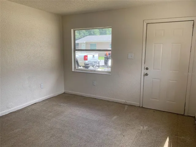 an empty room with windows and closet