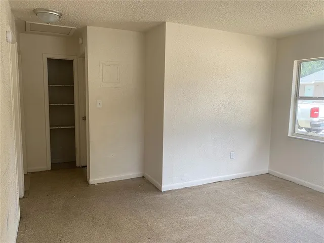 an empty room with windows and closet