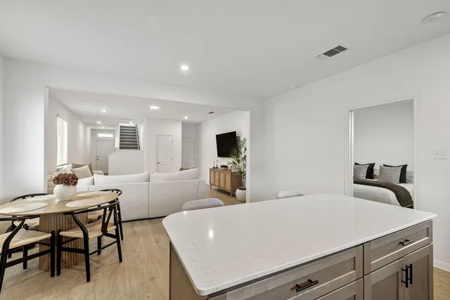 a living room with furniture a flat screen tv and kitchen view