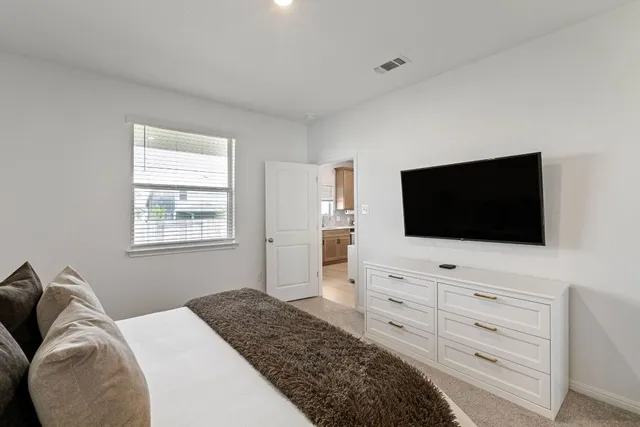 a bedroom with a bed and a flat screen tv