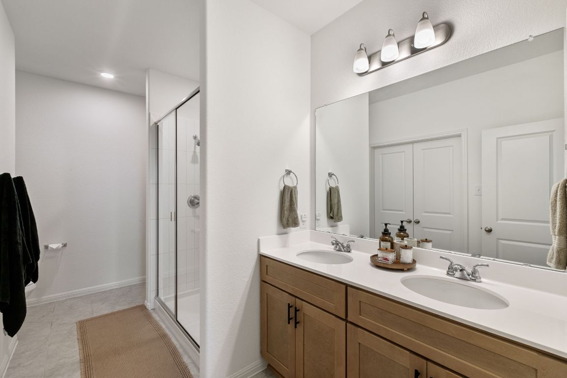 615 Backstays Loop Kyle, TX 78640 - Photo 16 of 36 a bathroom with a double vanity sink and a mirror