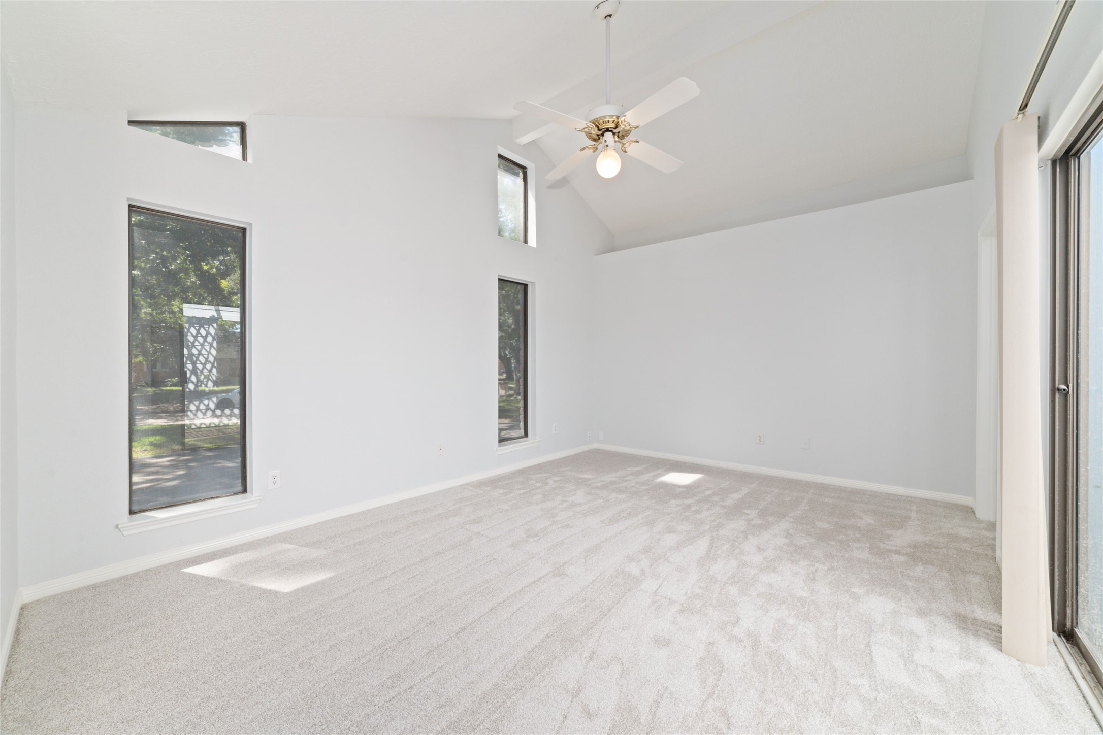 15014 Tinker Street Houston, TX 77084 - Photo 22 of 35 en empty room with windows and chandelier fan