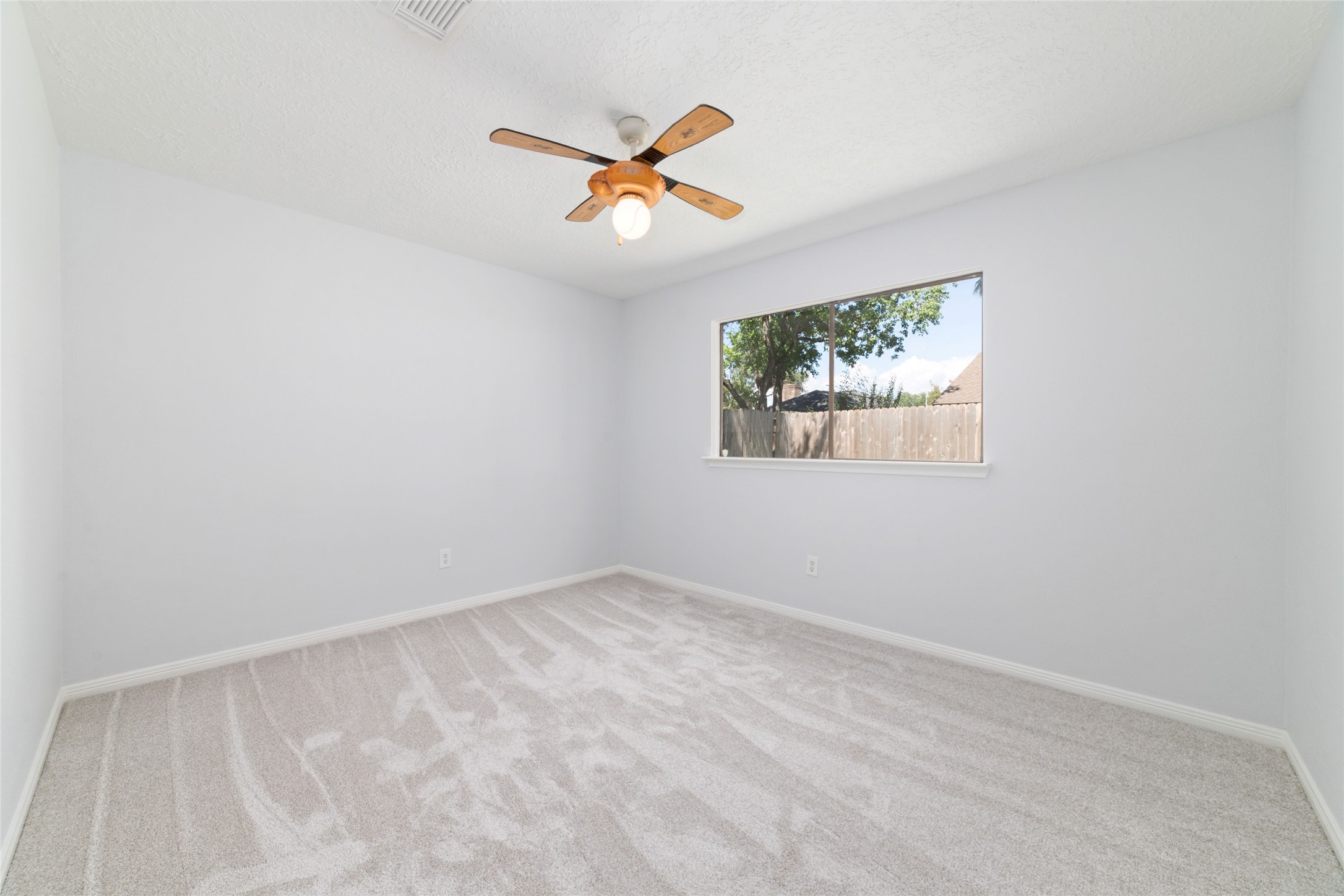 15014 Tinker Street Houston, TX 77084 - Photo 31 of 35 an empty room with a window and a ceiling fan