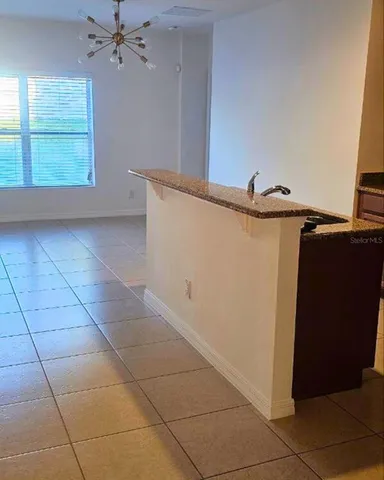 a view of a livingroom with an empty space and a window