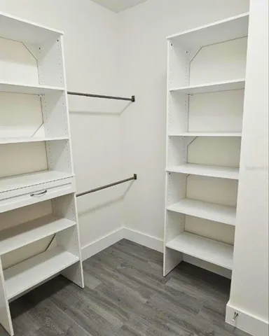 a view of walk in closet with empty racks