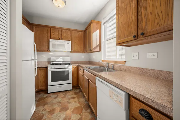 a kitchen with granite countertop a sink stainless steel appliances and cabinets