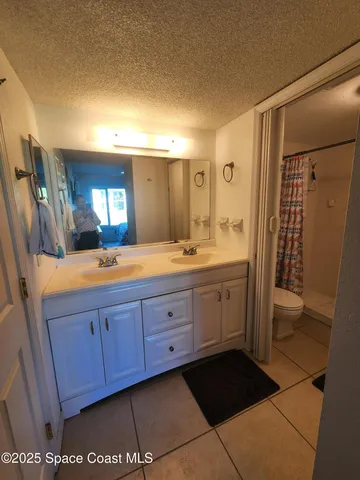 a spacious bathroom with a double vanity sink a mirror and a shower