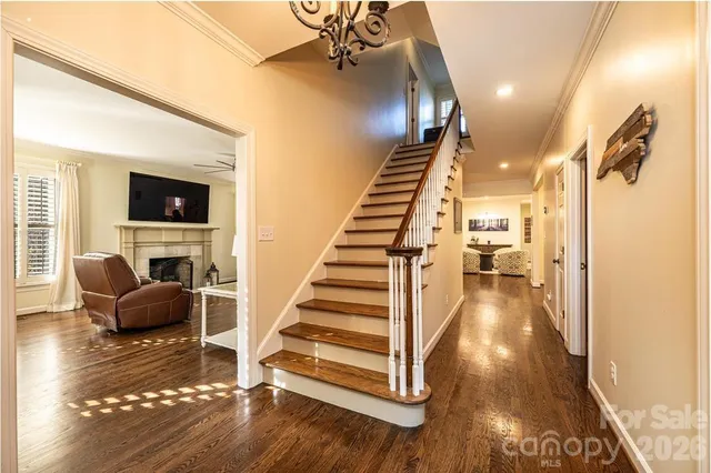 a view of a dining room and livingroom with furniture wooden floor a chandelier