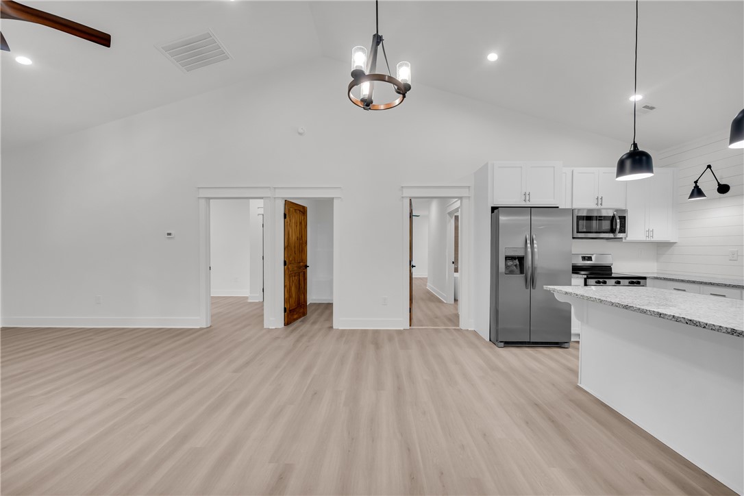 659 White Oak Farms Road Tamassee, SC 29686 - Photo 16 of 50 Gleaming stone counters and warm wood floors anchor this open-concept architectural design.