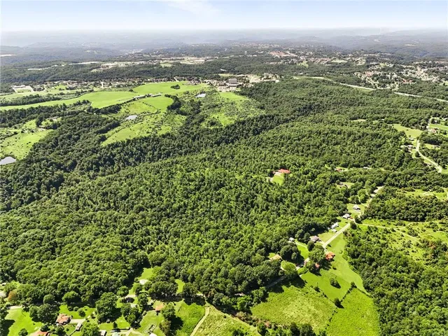 an aerial view of residential houses with outdoor space and trees