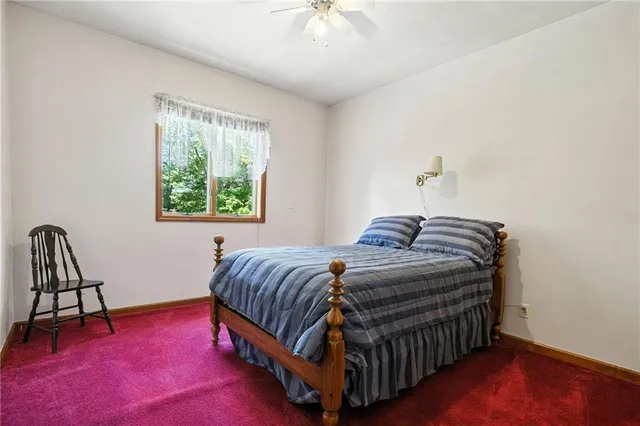 a bedroom with a bed chair and a window