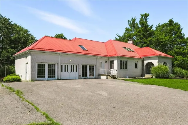 a front view of a house with yard and trees