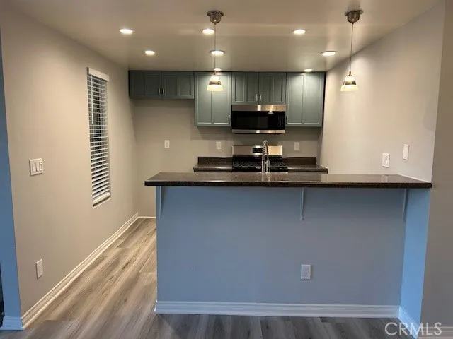 a view of kitchen with stainless steel appliances granite countertop refrigerator sink and stove