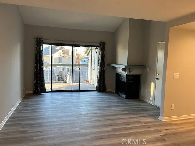 a view of empty room with wooden floor and windows