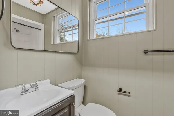 a bathroom with a sink mirror and toilet