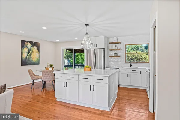 a large white kitchen with wooden floor