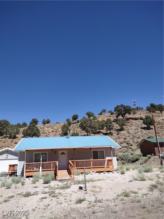 301 South Gold Street Manhattan, NV 89022 - Photo 1 of 16 View of front of property with a metal roof and covered porch