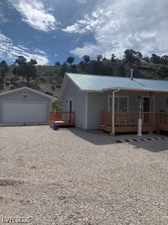 301 South Gold Street Manhattan, NV 89022 - Photo 2 of 16 View of front of property with a metal roof, a detached garage, an outdoor structure, and a wooden deck