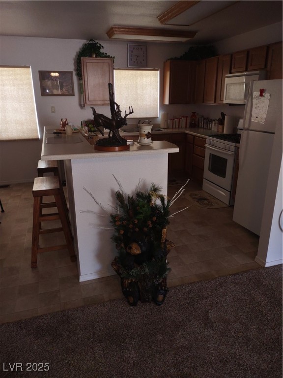 301 South Gold Street Manhattan, NV 89022 - Photo 10 of 16 Kitchen featuring refrigerator, stove, light countertops, a kitchen breakfast bar, and a center island