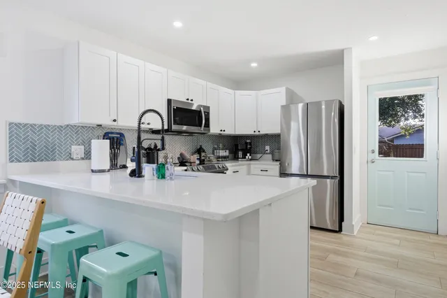 a kitchen with kitchen island a refrigerator sink and wooden cabinets