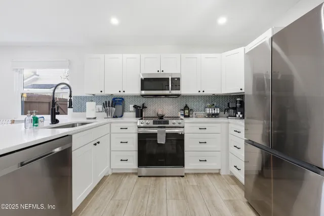 a kitchen with stainless steel appliances a stove sink and cabinets
